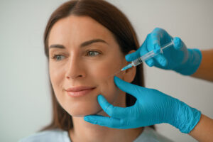 Cosmetologist injecting collagen to her clients face